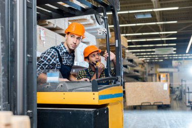 özenli işçi walkie talkie konuşurken onun Hint meslektaşım yakın forklift makinede oturan