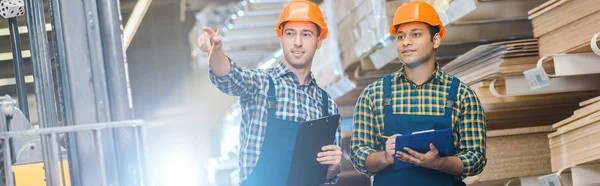 Panoramic Shot Warehouse Worker Pointing Finger While Standing Indian Friend — Stock Photo, Image