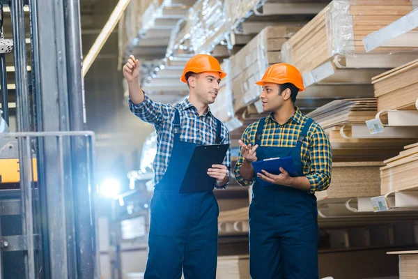 Sonriente Trabajador Señalando Con Lápiz Mientras Habla Con Colega Indio — Foto de Stock