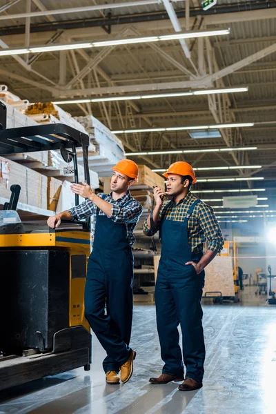 Concentrated Multicultural Workers Helmets Plaid Shirts Standing Forklift Machine — Stock Photo, Image