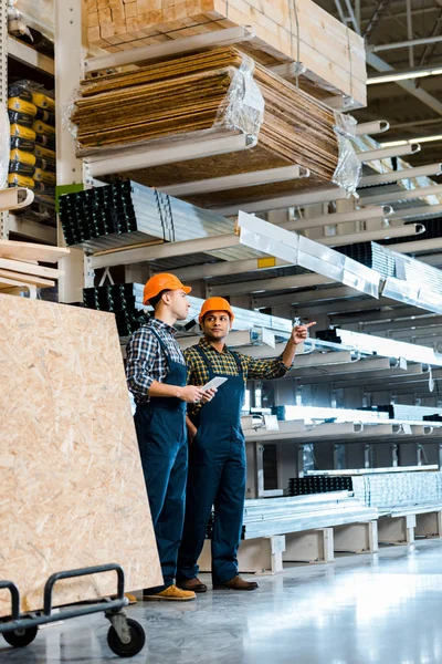 Handsome Indian Worker Pointing Finger While Standing Colleague Warehouse — Stock Photo, Image