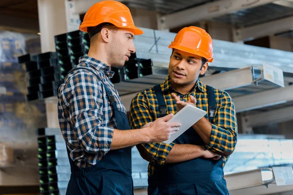 Trabajadores Almacenes Multiculturales Concentrados Que Hablan Mientras Usan Tabletas Digitales —  Fotos de Stock