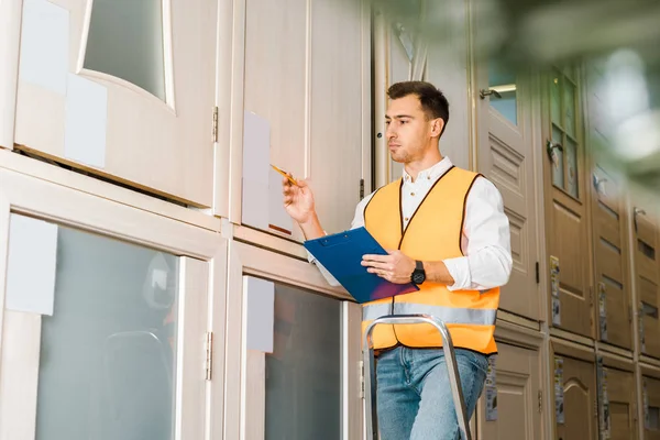 Selective Focus Worker Safety Vest Standing Ladder Warehouse — Stock Photo, Image