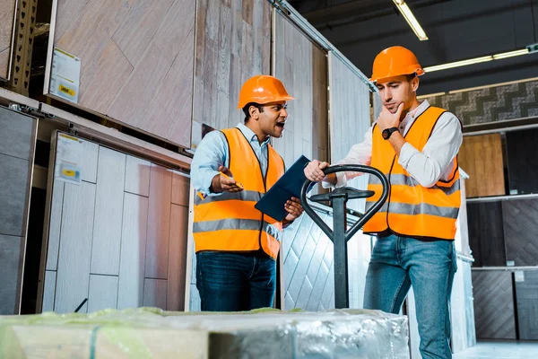 Upset Warehouse Worker Pallet Jack Standing Angry Yelling Indian Colleague — Stock Photo, Image