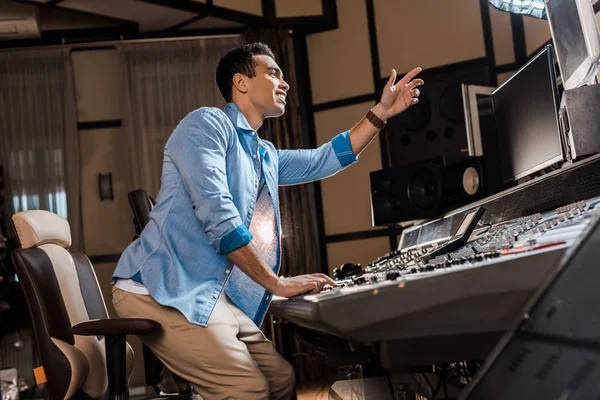 Handsome Mixed Race Musician Gesturing While Working Mixing Console — Stock Photo, Image