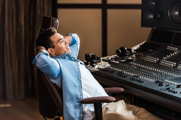 Yakışıklı Gülümseyen Karışık Irk Ses Yapımcısı Kayıt Stüdyosunda Ofis Sandalyesinde — Stok fotoğraf