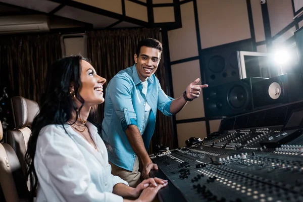 Sorrindo Produtor Som Bonito Apontando Com Dedo Perto Colega Muito — Fotografia de Stock