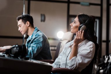 yakışıklı ses yapımcısı karıştırma konsolunda çalışırken meslektaşı kulaklık müzik dinlerken