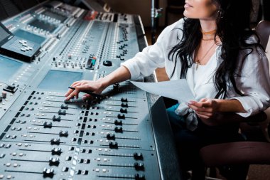 cropped view of sound producer working in recording studio at mixing console clipart