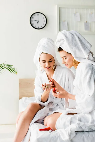 Smiling Stylish Women Bathrobes Jewelry Towels Heads Sitting Bed Polishing — Stock Photo, Image