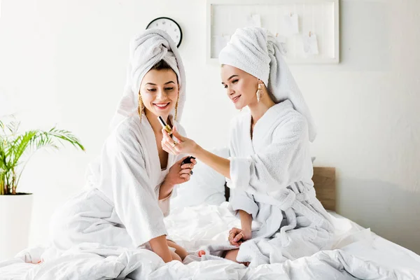 Happy Stylish Women Bathrobes Jewelry Towels Heads Sitting Bed Looking — Stock Photo, Image