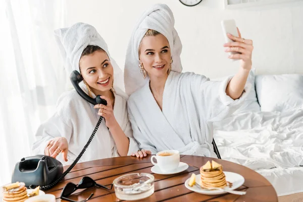 Stylish Women Bathrobes Jewelry Towels Heads Talking Retro Phone Smiling — Stock Photo, Image