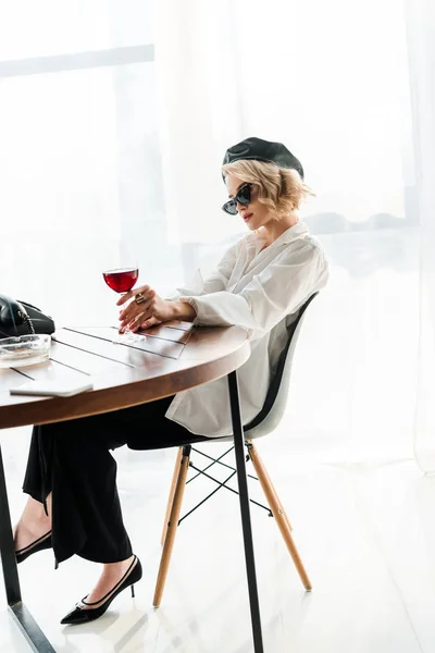 Elegante Donna Bionda Berretto Nero Occhiali Sole Seduta Tavola Con — Foto Stock