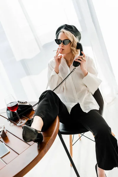Elegant Blonde Woman Black Beret Sunglasses Sitting Leg Table Smoking — Stock Photo, Image