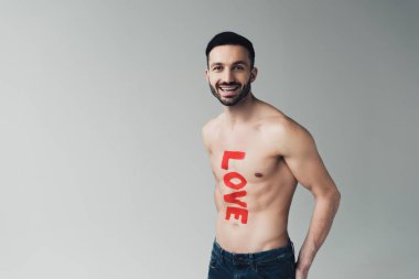 Gri üzerinde vücut üzerinde yazıt ile kot gülme adam