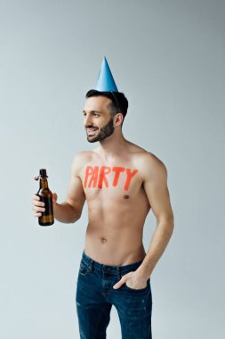 Parti şapkasında bira tutan ve gri üzerinde izole görünümlü adam