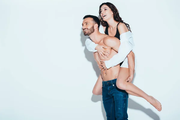 Sorrindo Bonito Homem Carregando Namorada Piggyback Cinza — Fotografia de Stock