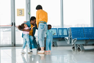 havaalanında mutlu Afrikalı Amerikalı adam sarılmak çocuklar