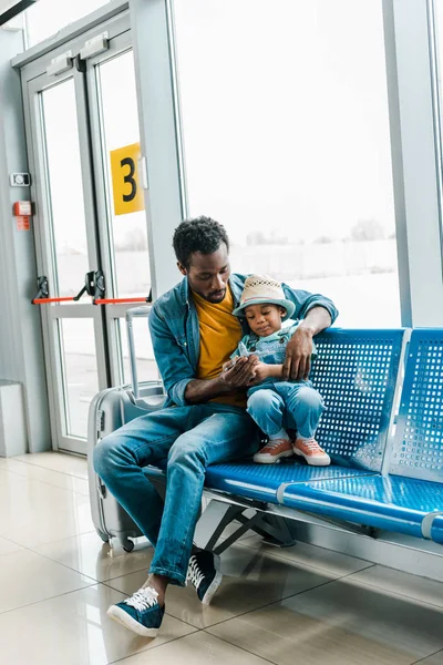 Αφρικανός Αμερικανός Πατέρας Κάθεται Στην Αίθουσα Αναμονής Στο Αεροδρόμιο Και — Φωτογραφία Αρχείου