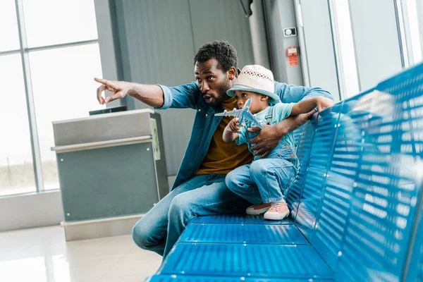 Africano Americano Padre Apuntando Con Dedo Lejos Mientras Hijo Celebración —  Fotos de Stock