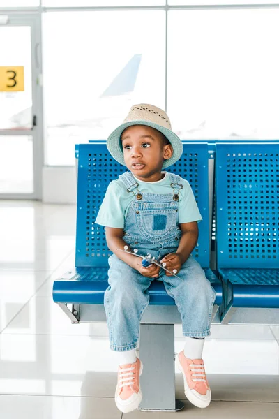 Bonito Confuso Afro Americano Menino Sentado Com Brinquedo Avião Aeroporto — Fotografia de Stock