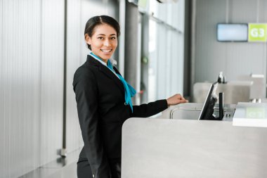 masada kontrol ve kamera bakarak üniforma ayakta gülümseyen Afrikalı Amerikan Havaalanı personeli