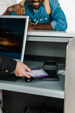 cropped view of airport worker scanning air ticket at ticket control in airport clipart