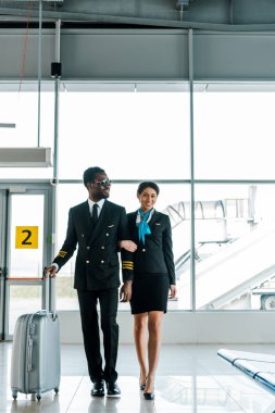 Afrika Amerikan pilot ve hostes havaalanında birlikte yürüyüş
