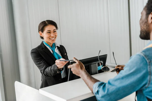 Smiling African American Airport Worker Giving Documents Tourist — Stock Photo, Image