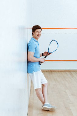 Mavi polo gömlek squash oyuncu tam uzunlukta görünümü kameraya bakarak