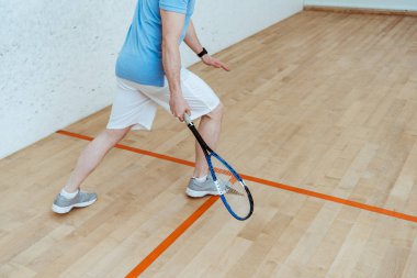 Squash oynayan beyaz şortlu sporcunun kırpılmış görünümü