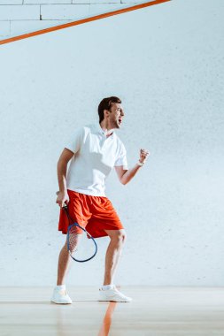 Evet jest gösteren raket ile mutlu squash oyuncu tam uzunlukta görünümü