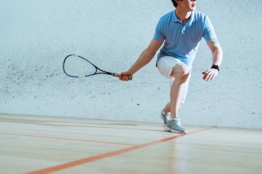 Squash oynayan mavi polo gömlek sporcu kısmi görünümü