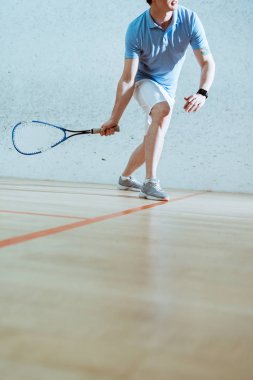 Squash oynayan mavi polo gömlek sporcu kısmi görünümü
