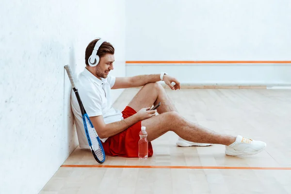 Lecteur Squash Souriant Écoutant Musique Dans Casque Utilisant Smartphone — Photo