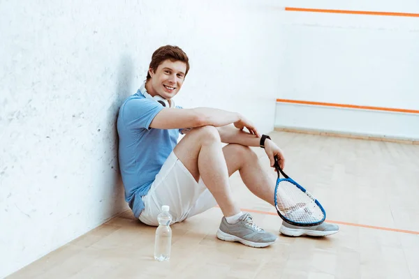 Skrattande Squash Spelare Sitter Golvet Och Tittar Kameran — Stockfoto