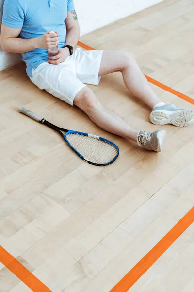 Vista Ritagliata Del Giocatore Squash Seduto Sul Pavimento Con Mano — Foto Stock
