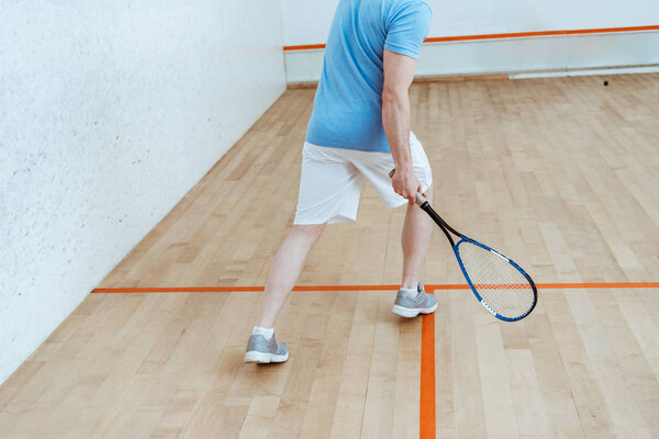 Cropped view of sportsman in white shorts playing squash