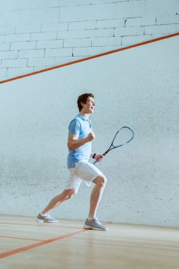 Full length view of happy squash player showing yes gesture clipart