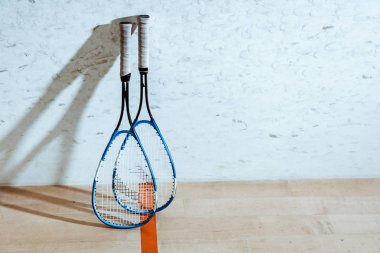 Two squash rackets on wooden floor in four-walled court clipart
