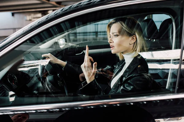 Attractive Blonde Woman Showing Middle Finger While Driving Car — Stock Photo, Image