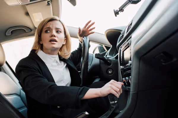 Niski Kąt Widzenia Emocjonalnej Blond Kobieta Wskazując Siedząc Samochodzie — Zdjęcie stockowe