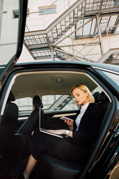 Låg Vinkel Bild Attraktiv Blond Kvinna Håller Smartphone Nära Laptop — Stockfoto