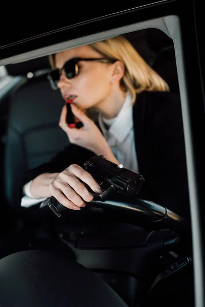 Selective Focus Gun Hand Attractive Blonde Woman Applying Lipstick Car — Stock Photo, Image