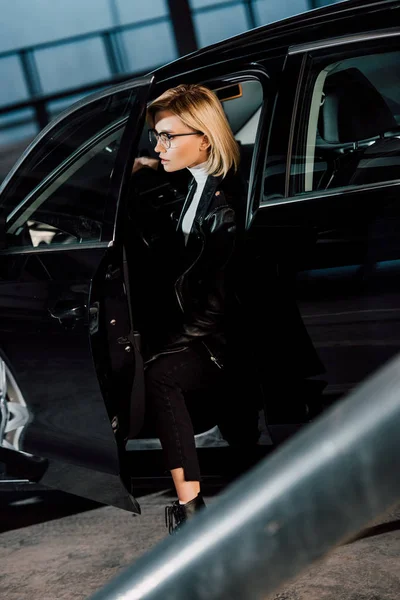 Ελκυστική Νεαρή Ξανθιά Γυναίκα Γυαλιά Που Κάθονται Μαύρο Αυτοκίνητο — Φωτογραφία Αρχείου