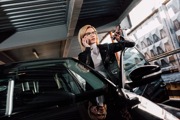 Pretty Blonde Girl Glasses Talking Smartphone Gesturing Black Car — Stock Photo, Image