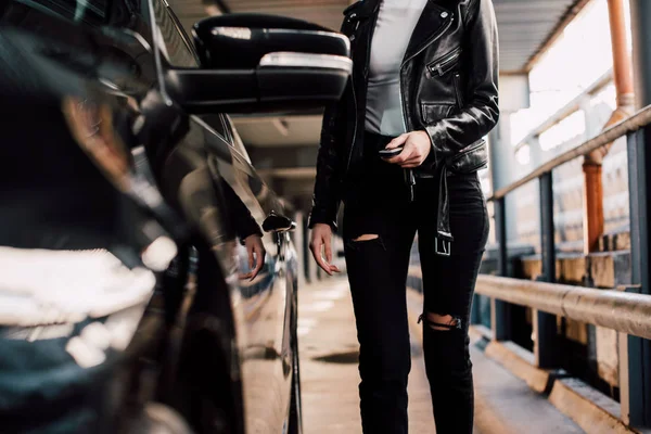 Vista Cortada Menina Segurando Chave Com Chaveiro Perto Carro Preto — Fotografia de Stock