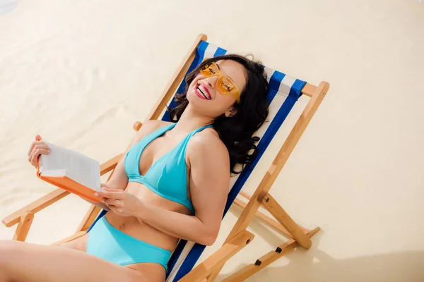 Hermosa Feliz Bikini Chica Tumbado Silla Cubierta Con Libro Playa — Foto de Stock
