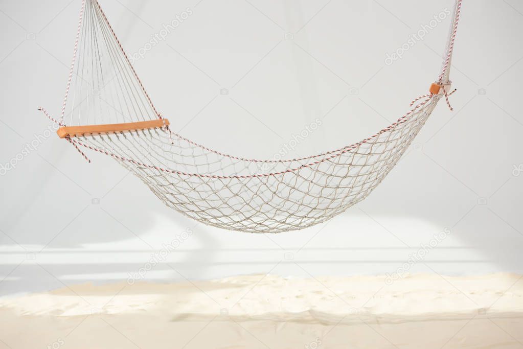 hanging hammock made of net over sand on grey