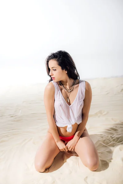 美丽的性感女孩在湿顶部坐和在沙滩上摆姿势 — 图库照片